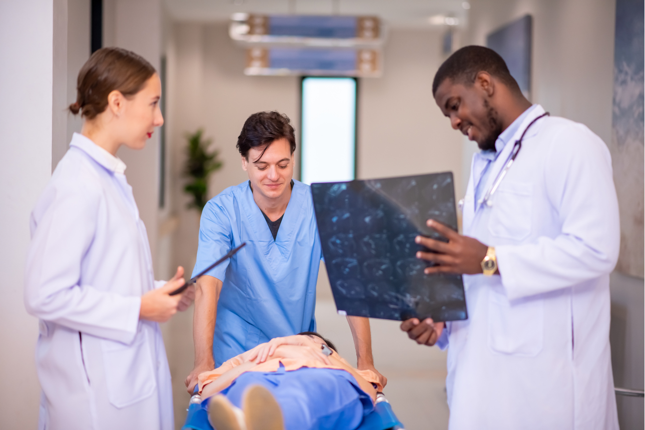 Doctor reviewing x-ray with nurse, co-doctor, and patient