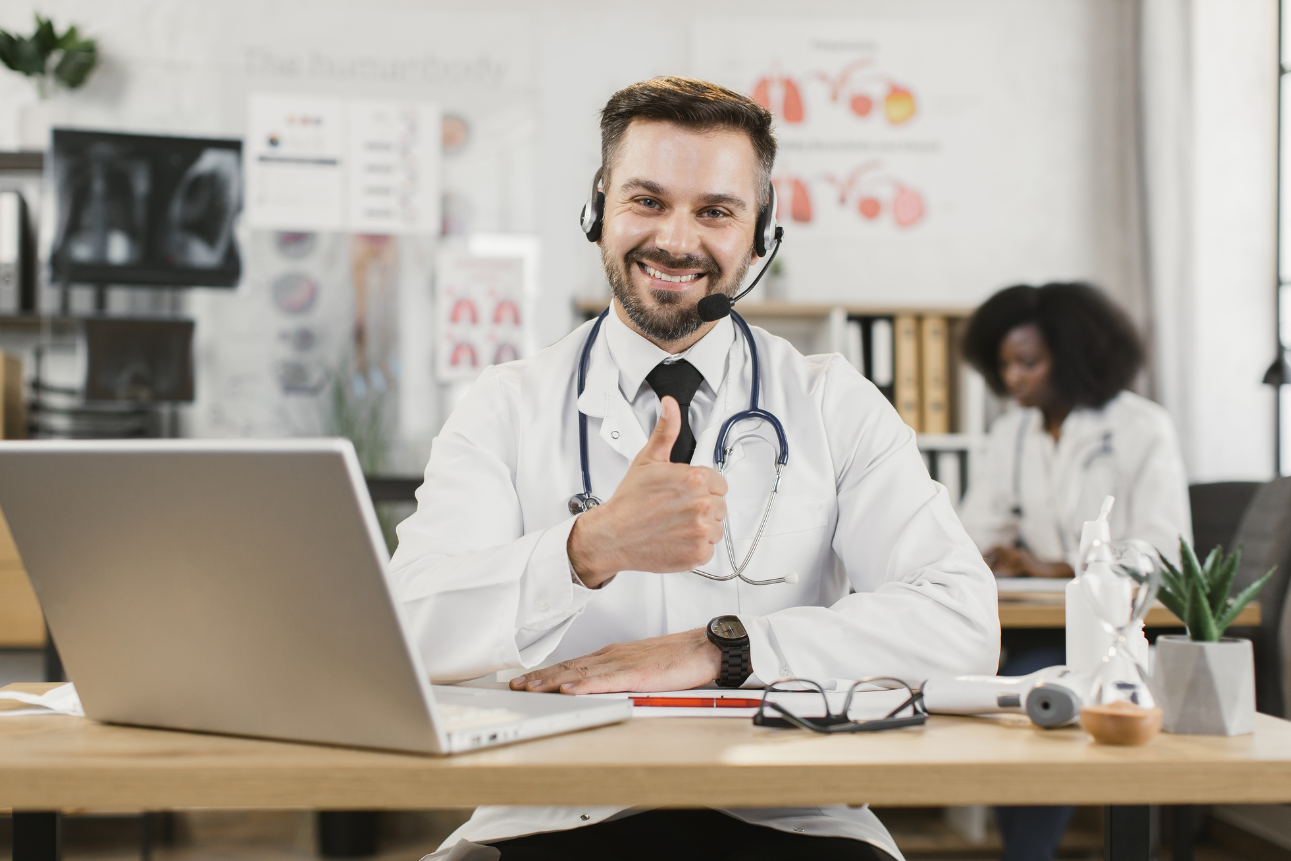 Doctor wearing headset during telehealth consultation via laptop