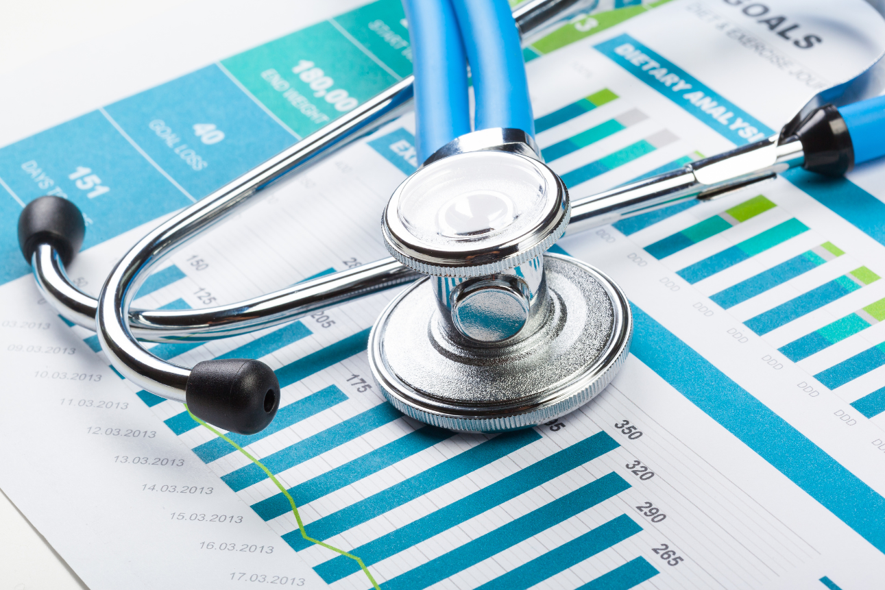 Stethoscope and financial documents on office desk
